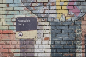 A sign on a brick wall says Accessible Entrance